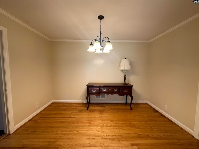 interior space featuring an inviting chandelier, ornamental molding, and light hardwood / wood-style flooring