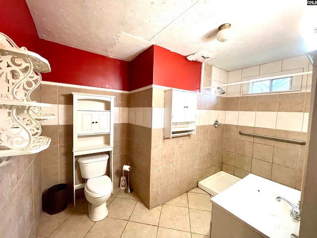 bathroom featuring a shower, tile patterned floors, tile walls, and toilet