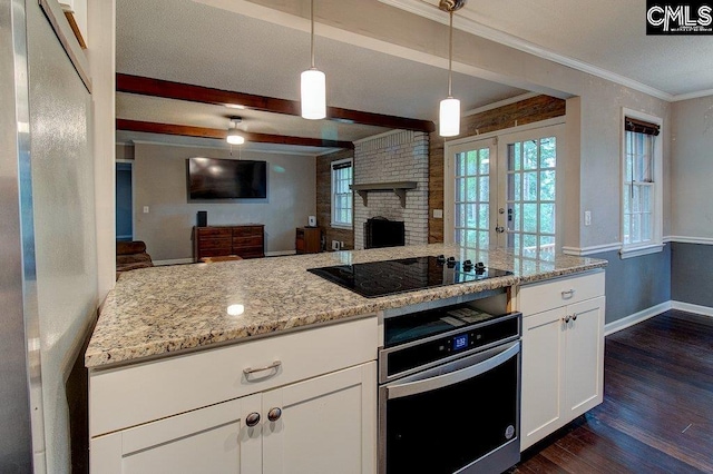 kitchen featuring dark hardwood / wood-style floors, light stone countertops, a fireplace, decorative light fixtures, and white cabinetry