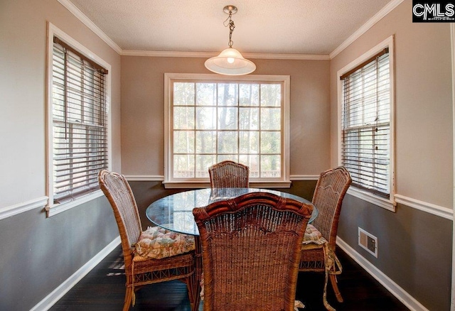 dining space with a wealth of natural light, dark wood-type flooring, and ornamental molding