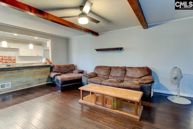 living room featuring beam ceiling, dark hardwood / wood-style flooring, a textured ceiling, and ceiling fan