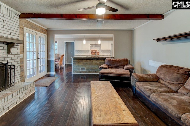 living room featuring beam ceiling, a textured ceiling, crown molding, and dark wood-type flooring