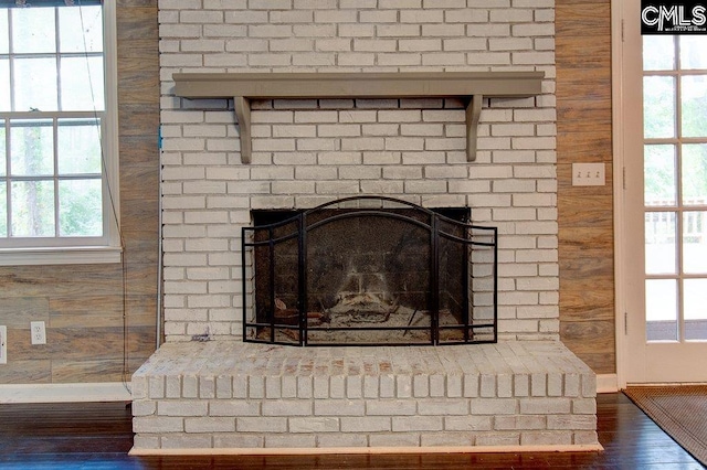 interior details featuring a fireplace, wood-type flooring, and wood walls