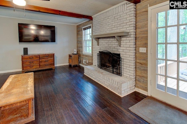 unfurnished living room with dark hardwood / wood-style floors, wood walls, plenty of natural light, and a fireplace