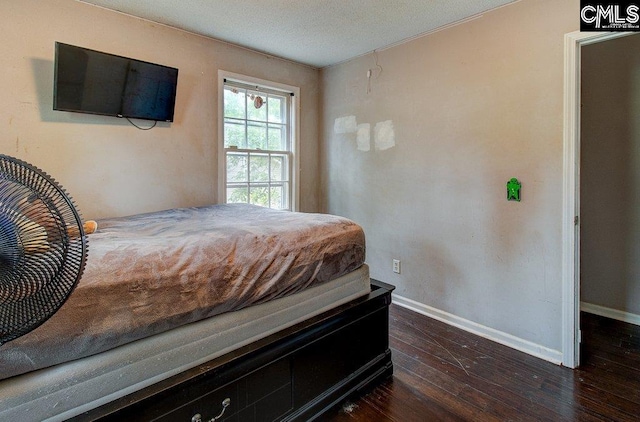 bedroom with dark hardwood / wood-style flooring and a textured ceiling