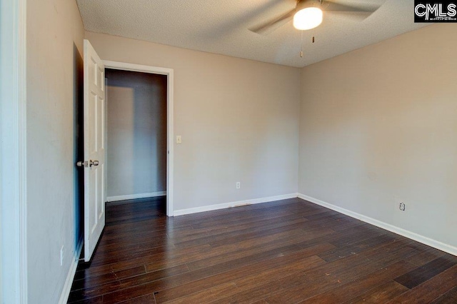 spare room with dark hardwood / wood-style floors, ceiling fan, and a textured ceiling