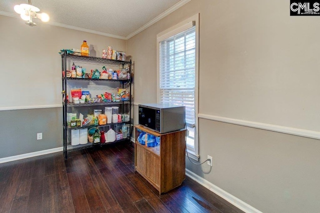 rec room with ornamental molding, dark wood-type flooring, and an inviting chandelier