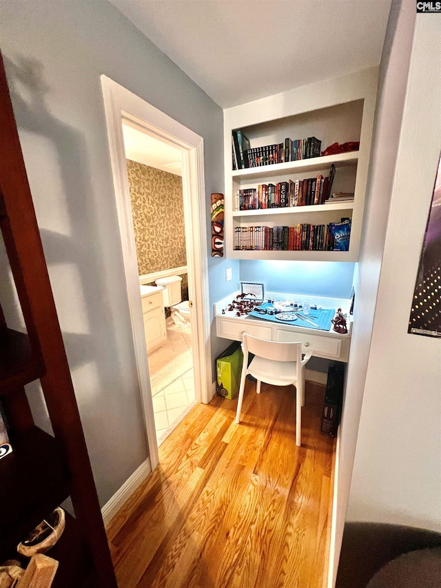 home office featuring built in desk and light wood-type flooring