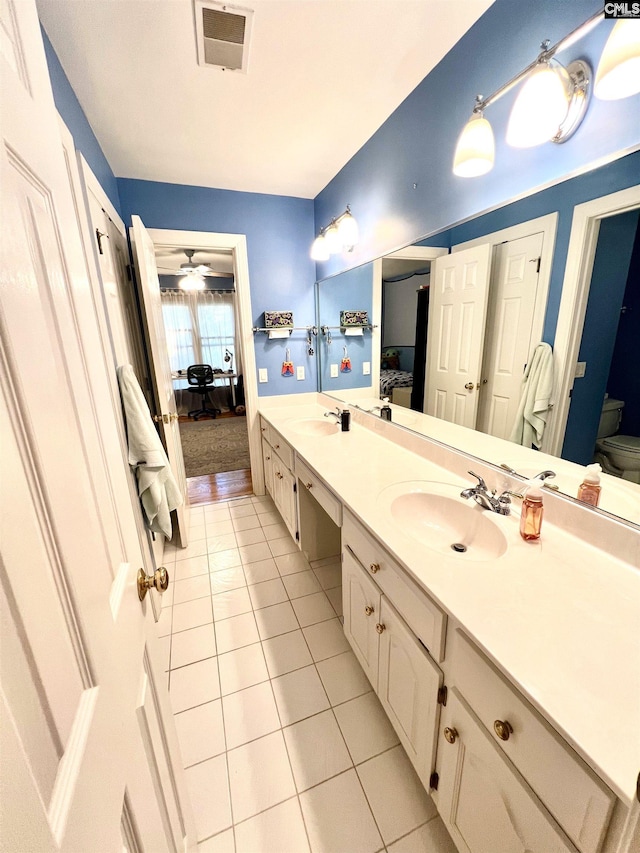 bathroom with toilet, vanity, tile patterned floors, and ceiling fan