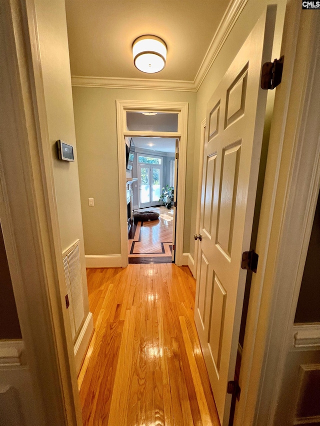 hall featuring light wood-type flooring and ornamental molding