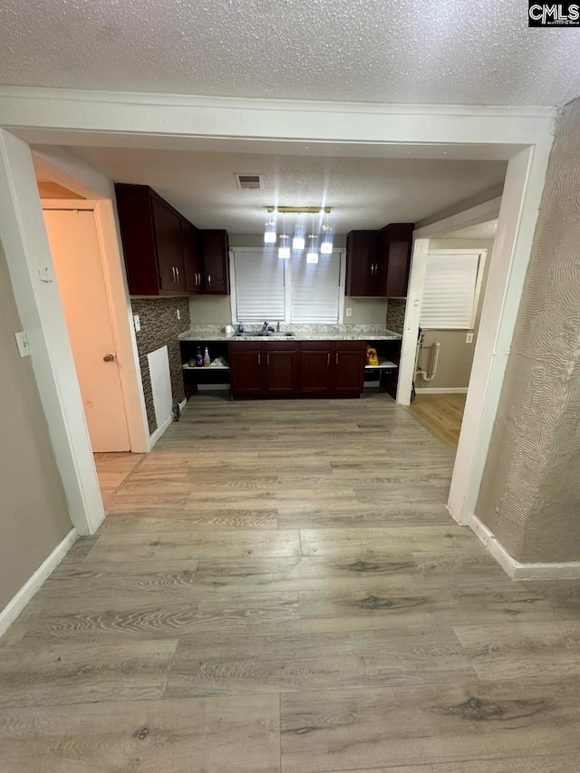 kitchen with dark brown cabinets and light hardwood / wood-style floors