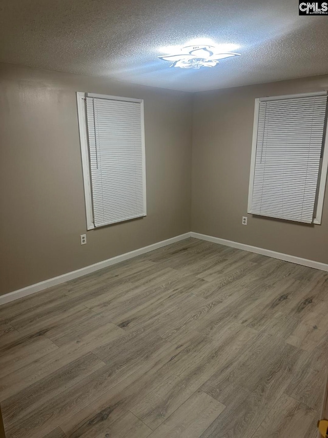 spare room with hardwood / wood-style floors and a textured ceiling