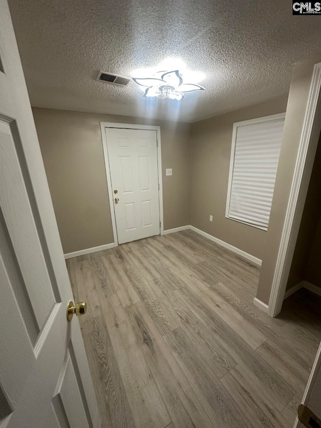 interior space with light hardwood / wood-style floors and a textured ceiling