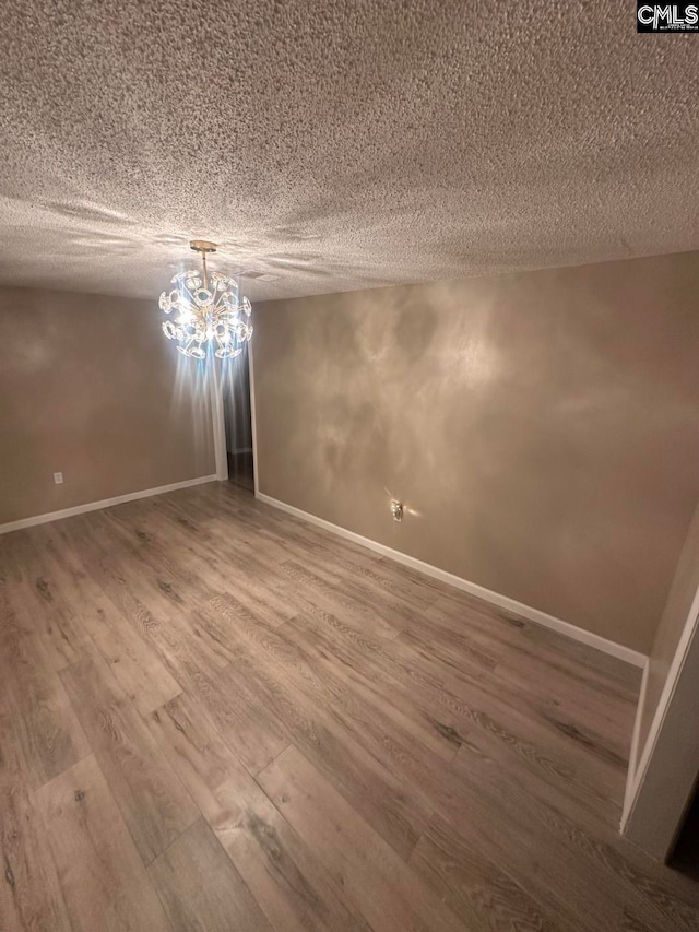 empty room with hardwood / wood-style floors and a textured ceiling