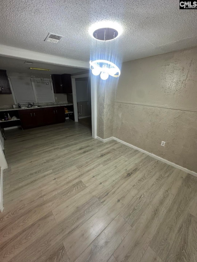 unfurnished dining area with hardwood / wood-style flooring and a textured ceiling