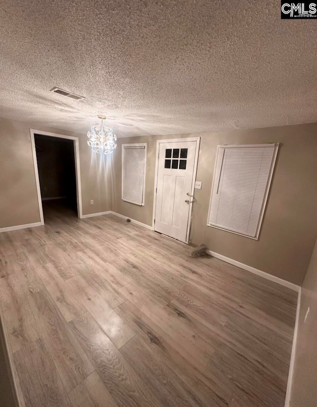 interior space featuring a chandelier, hardwood / wood-style floors, and a textured ceiling