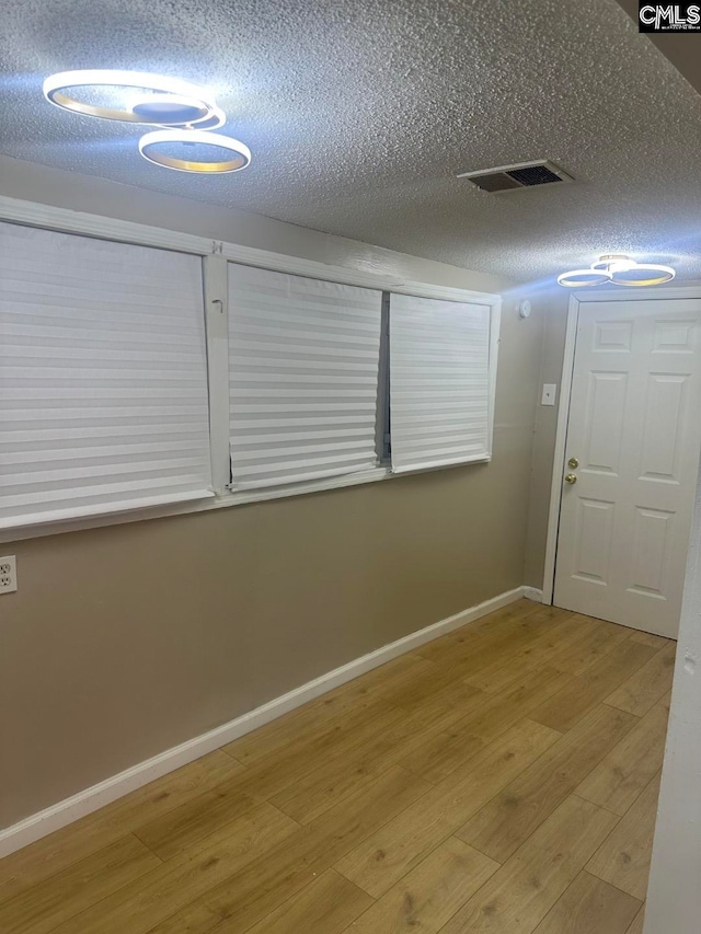 interior space featuring a textured ceiling and light hardwood / wood-style floors