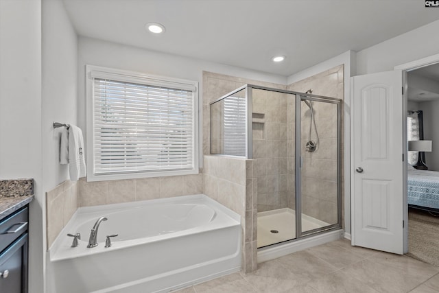 bathroom with tile patterned floors, vanity, and shower with separate bathtub