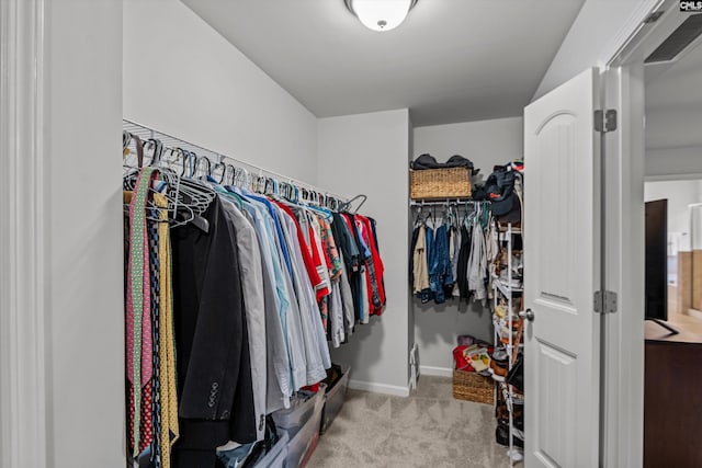 walk in closet featuring light colored carpet