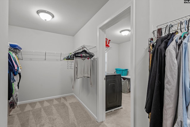 walk in closet with light carpet and washer and dryer