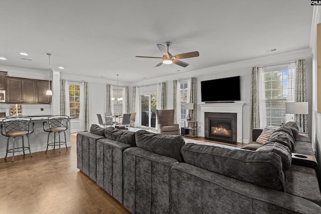 living room with dark hardwood / wood-style floors, ceiling fan, and crown molding