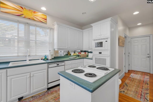 kitchen featuring white cabinets, light wood-type flooring, sink, and white appliances