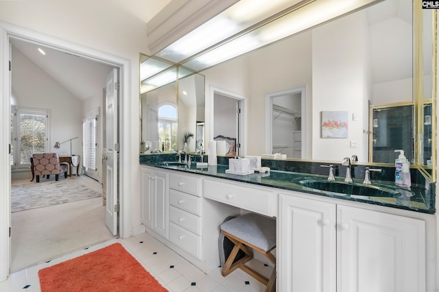 bathroom with tile patterned floors, vanity, and lofted ceiling