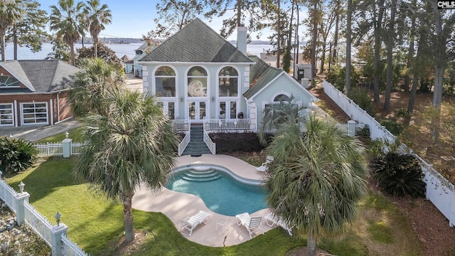 rear view of property with a fenced in pool, a yard, and a patio