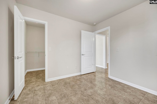 unfurnished bedroom featuring a walk in closet and a closet