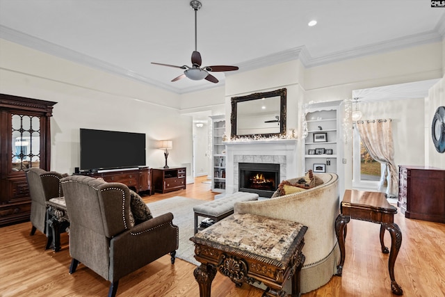 living room featuring light hardwood / wood-style flooring, ceiling fan, and crown molding