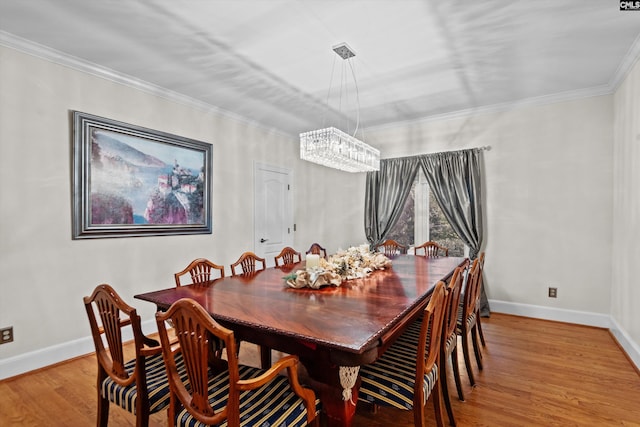 dining area with hardwood / wood-style flooring, crown molding, and a chandelier