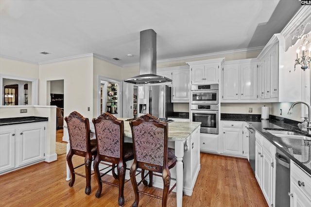 kitchen with appliances with stainless steel finishes, sink, light hardwood / wood-style flooring, white cabinetry, and range hood