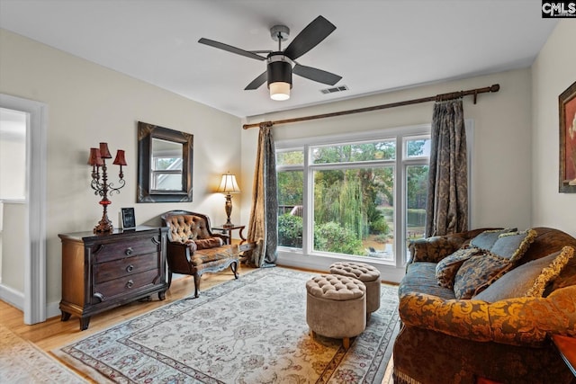 living area with ceiling fan and light hardwood / wood-style flooring