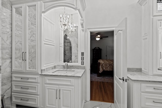 bathroom with ceiling fan with notable chandelier, vanity, and hardwood / wood-style flooring