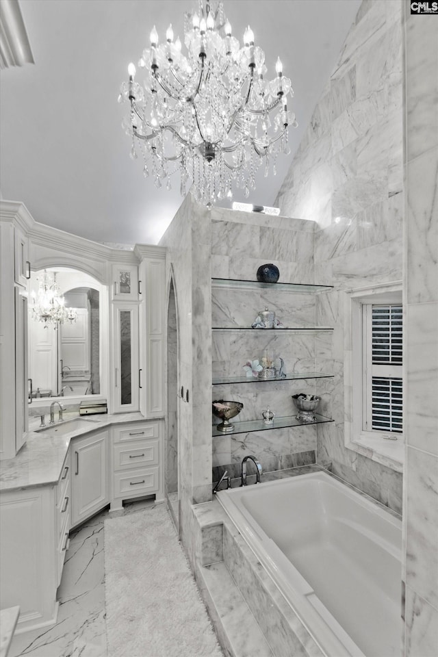 bathroom with vanity, a notable chandelier, lofted ceiling, and tiled tub