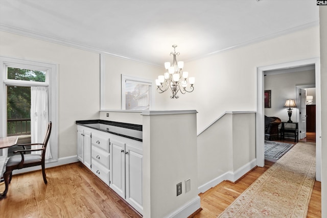 dining room with a notable chandelier, crown molding, and light hardwood / wood-style flooring