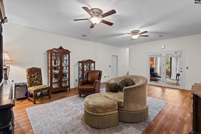 living room featuring ceiling fan, crown molding, and light hardwood / wood-style flooring