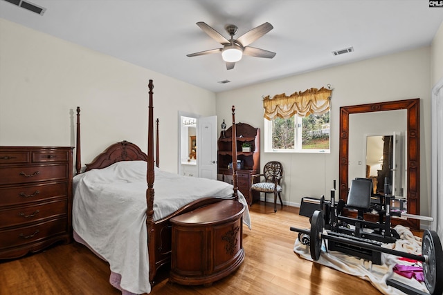 bedroom with connected bathroom, ceiling fan, and wood-type flooring