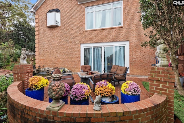 back of house with an outdoor fire pit and a patio area