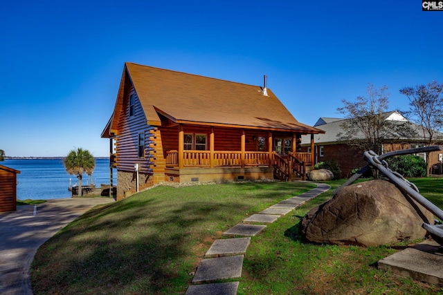 log-style house featuring covered porch, a water view, and a front lawn