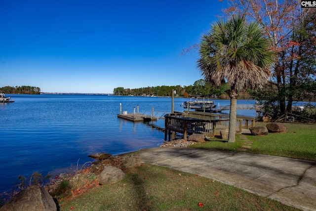 dock area featuring a water view and a lawn