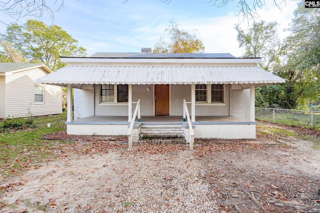 bungalow-style house with a porch and solar panels