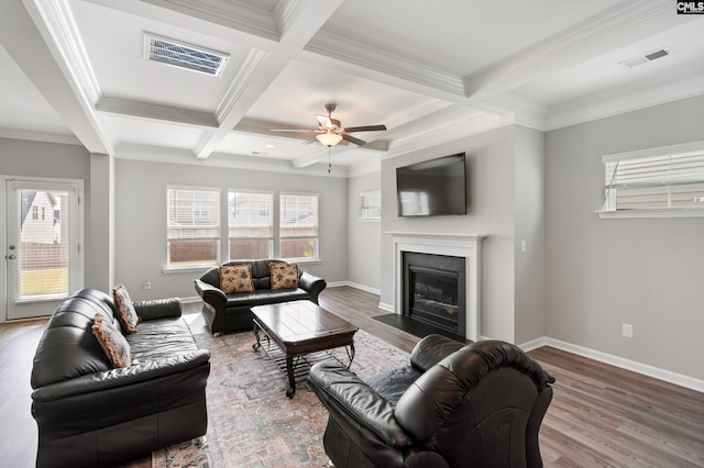 living room featuring ornamental molding, coffered ceiling, ceiling fan, hardwood / wood-style flooring, and beamed ceiling