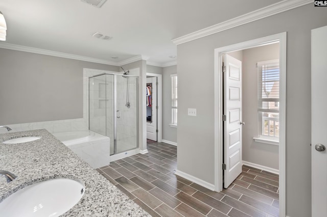 bathroom featuring crown molding, vanity, and shower with separate bathtub