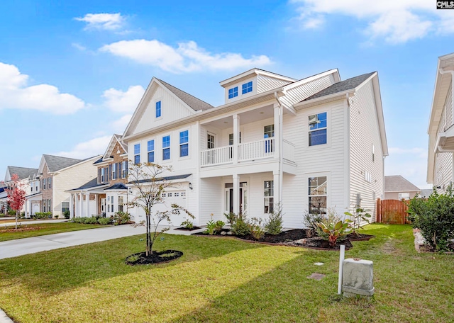 view of front facade featuring a front yard, a balcony, and a garage