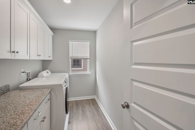 clothes washing area with cabinets, separate washer and dryer, and light wood-type flooring