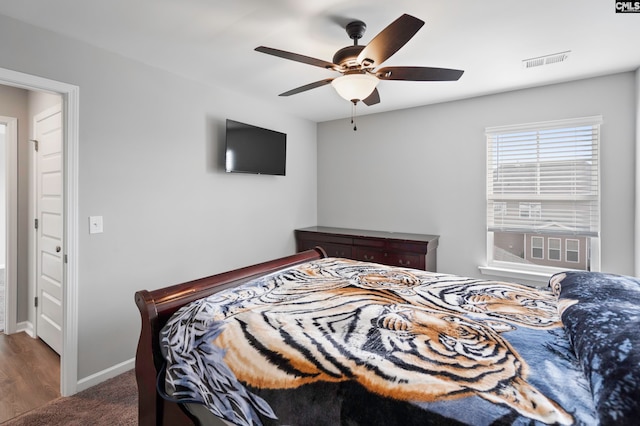 bedroom with dark hardwood / wood-style floors and ceiling fan