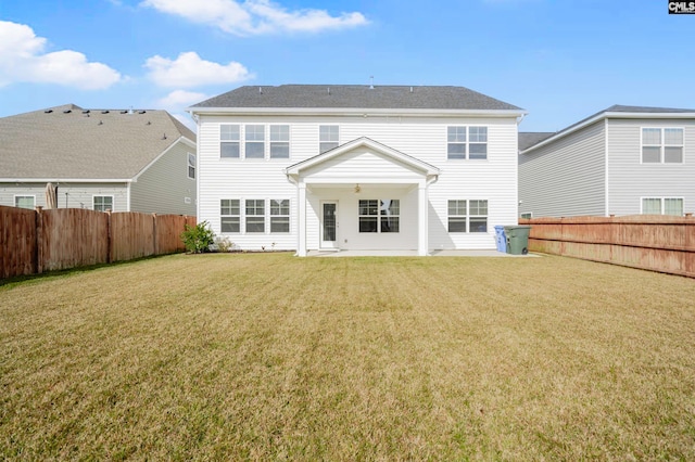 rear view of property featuring a lawn, ceiling fan, and a patio