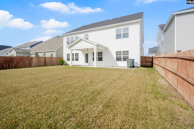 back of house with a yard and a patio