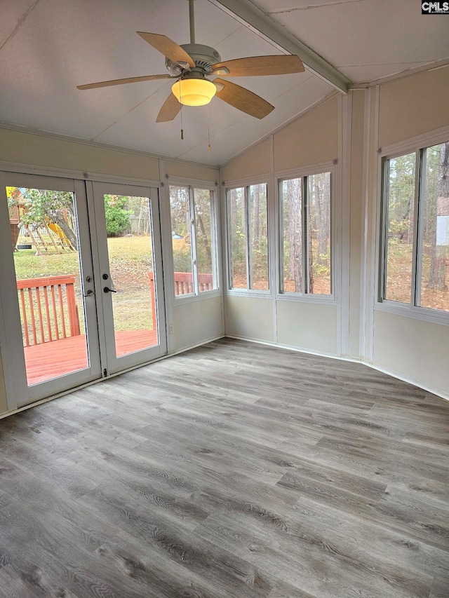 unfurnished sunroom featuring plenty of natural light, ceiling fan, lofted ceiling, and french doors